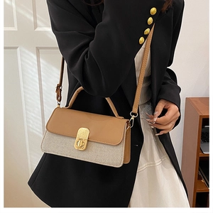 Detail of color-block crossbody bag featuring brown leather flap and woven texture