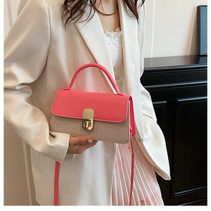 Detail der Umhängetasche aus rosa Leder und beigem Gewebe mit goldenem Drehverschluss