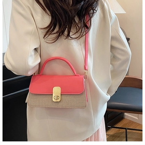 Detailed back view of a pink and beige woven crossbody bag worn with a white blazer