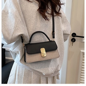 Details der zweifarbigen Tasche mit schwarzer Lederklappe und beiger Webstruktur