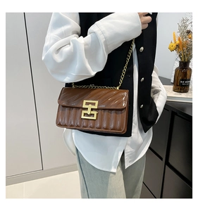 Sac bandoulière marron en cuir verni matelassé avec chaîne dorée sur mannequin