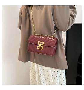 Vue détaillée du sac matelassé bordeaux avec chaîne dorée et fermoir géométrique
