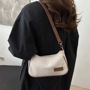 Retro cream woven underarm bag with brown leather trim shown on model for daily style
