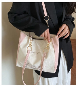 Detail of cute bear tote bag with pink straps and metallic ring chain on model