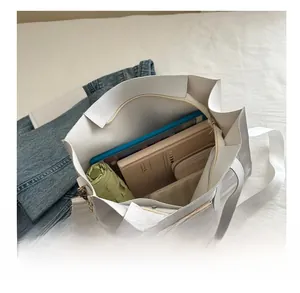 Interior view of white large capacity tote bag showing umbrella and books inside
