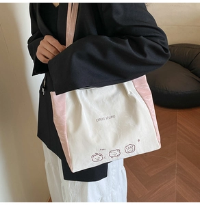 Detail of white and pink shoulder tote bag featuring cute cartoon bear print designs