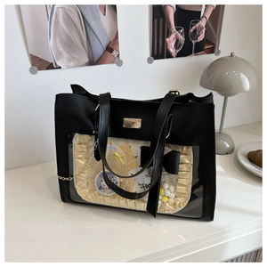 Detail of the black leather ita bag with a transparent window and yellow ribbon decor