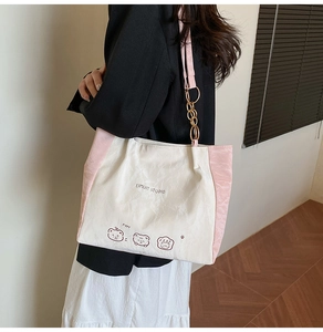 Detail of tote bag with bear print, pink straps, and gold chain decorative hardware