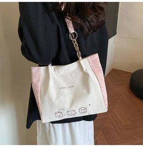 Detail of a pink and white tote bag showing contrast stitching and cute cartoon print