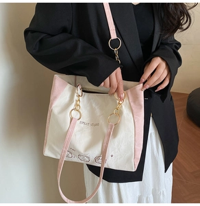 Detail of the white tote bag showing the cute bear illustration and pink shoulder strap