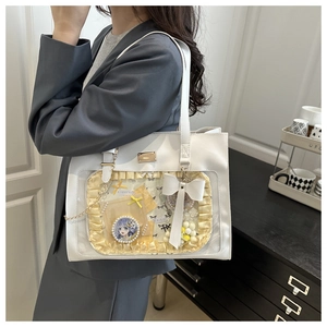 Detailed side view of white ita bag tote with clear display window and bow decorations