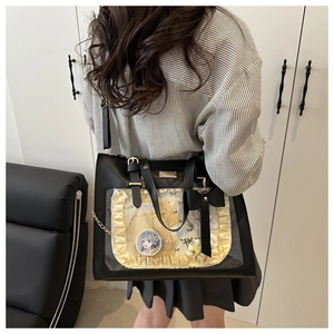 Close-up of black ita bag with clear window featuring lace trim and a large bow