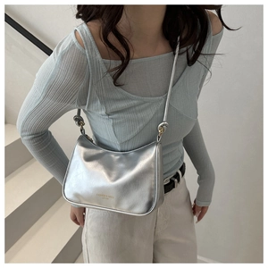 Detail of silver metallic crossbody bag with adjustable strap and minimalist lettering