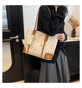 Mannequin portant un grand sac cabas en toile crème avec finitions en cuir brun et lettres