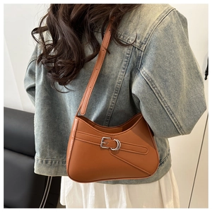 Bolso hobo de cuero marrón con hebilla al hombro con un atuendo casual