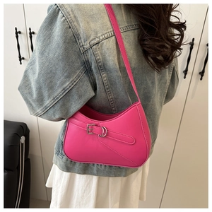 Detail view of bright pink shoulder bag with silver buckle strap and PU leather texture