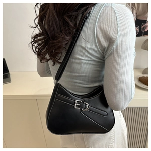 Model wearing the black crescent underarm bag with silver buckle and sleek faux leather
