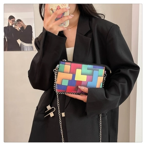 Detailansicht der bunten geometrischen Umschlagtasche mit silberner Perlenkette-Riemen