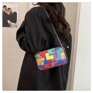Detail einer Umhängetasche mit buntem geometrischem Blockmuster und verzierten Perlenrändern