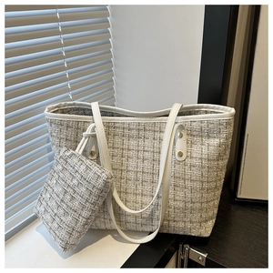 Close-up of a cream tweed tote bag and mini pouch set featuring premium woven texture