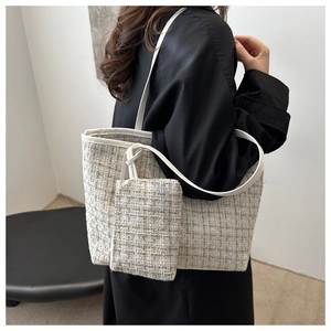Detailed close-up of a white tweed bucket bag with woven texture and matching coin purse