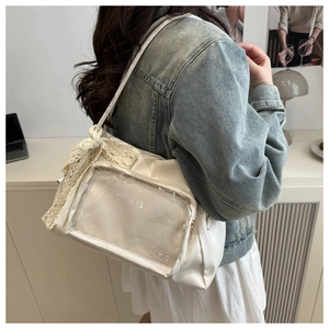 Detail of cream white Ita bag with transparent PVC window and decorative lace bow