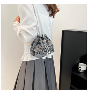 Détail du sac seau en soie noire avec imprimé paysage et bandoulière perle chic