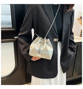 Détail du sac seau bleu brodé avec cordon en perles et fine bandoulière argentée