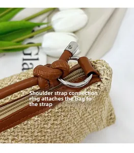 Close-up of metal D-ring attachment on straw bag with brown leather trim detail