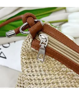 Detail of silver metal zipper and smooth slider on straw woven tote bag with leather trim