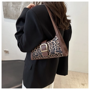 Dettaglio della borsa sottobraccio leopardata con finiture in pelle marrone e fibbia oro