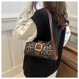Dettaglio borsa sottobraccio leopardata con finiture in pelle e chiusura in metallo oro