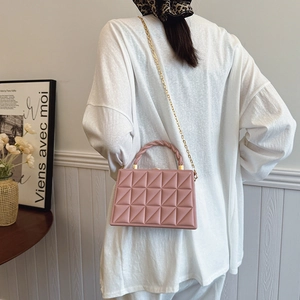 Pink quilted chain crossbody bag with gold hardware shown worn on a shoulder