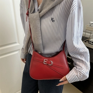 Chic dark red baguette underarm bag with silver buckle worn with a striped shirt