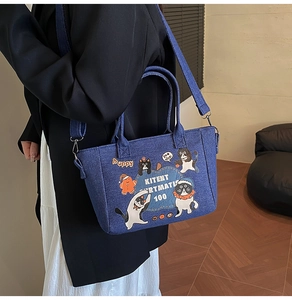 Close-up of denim tote bag featuring vintage cartoon prints and adjustable crossbody strap