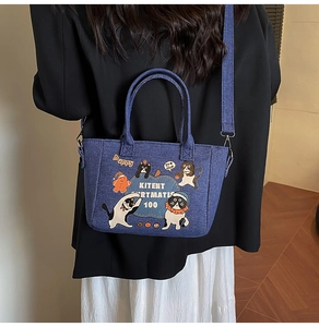 Rear view of a model carrying a denim tote bag with cute cartoon cat illustrations
