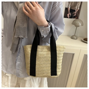 Close-up of beige woven texture and black canvas handles on this 2025 spring tote bag