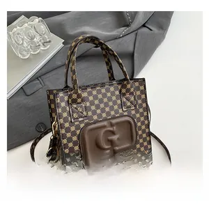 Detail of vintage monogrammed brown handbag with embossed large G logo and strap