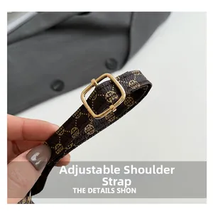 Detail of adjustable shoulder strap with retro monogram pattern and gold metal buckle