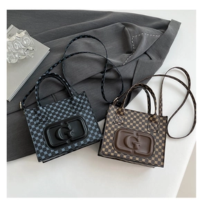 Close-up of retro tote bags in navy and brown with embossed G texture and long straps