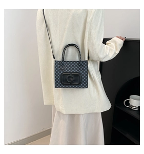 Detail of blue geometric jacquard tote bag with large matte G buckle and leather strap