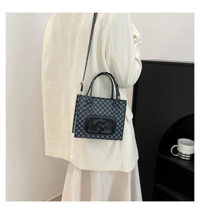 Detailed view of women's printed crossbody bag with G logo on a model in home setting