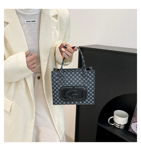 Detail of mini tote bag featuring embossed letter G and blue geometric dotted pattern