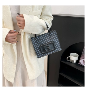 Detail view of mini square tote bag with blue dot pattern and embossed G logo