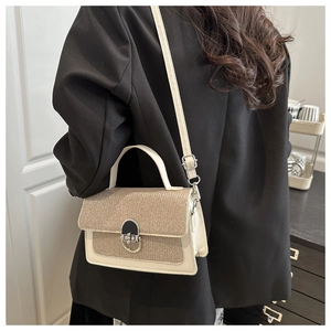 Vue détaillée d'un sac pailleté beige avec boucle argentée sur un blazer noir élégant