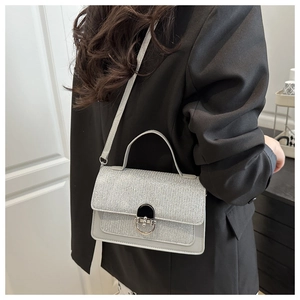 Dettaglio di borsa argento glitterata con elegante fibbia in metallo e texture