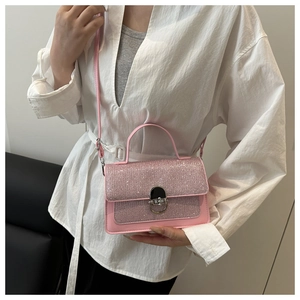 Detailed close-up of pink glitter PU leather handbag with silver twist lock and shoulder strap