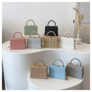 Collection of pleated geometric box bags in nine colors with chain straps and twisted handles