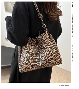 Detail of leopard print tote bag featuring a stylish knotted strap and silver ring buckle