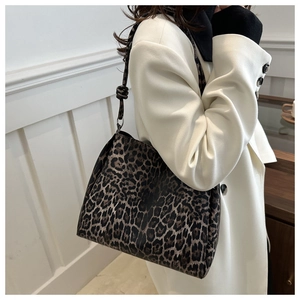 Close-up of stylish leopard print tote bag featuring a decorative knotted shoulder strap